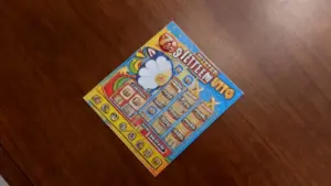 Un biglietto gratta e vinci colorato su un tavolo in legno.