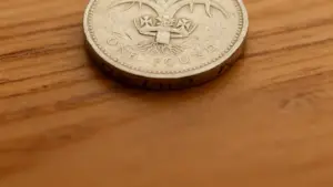 Dettaglio di una moneta da una sterlina poggiata su una superficie in legno
