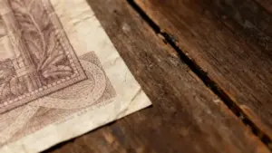 Angolo di una vecchia banconota appoggiata su un tavolo di legno