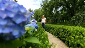 Una persona cammina in un giardino accanto a ortensie in fiore