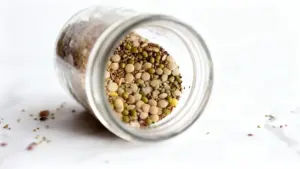Barattolo di vetro rovesciato con semi misti su una superficie chiara