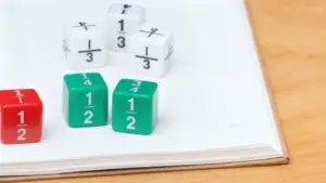 Dadi colorati con frazioni su un libro aperto su un tavolo di legno