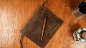 Vecchio libro rilegato in pelle con pennino su tavolo di legno