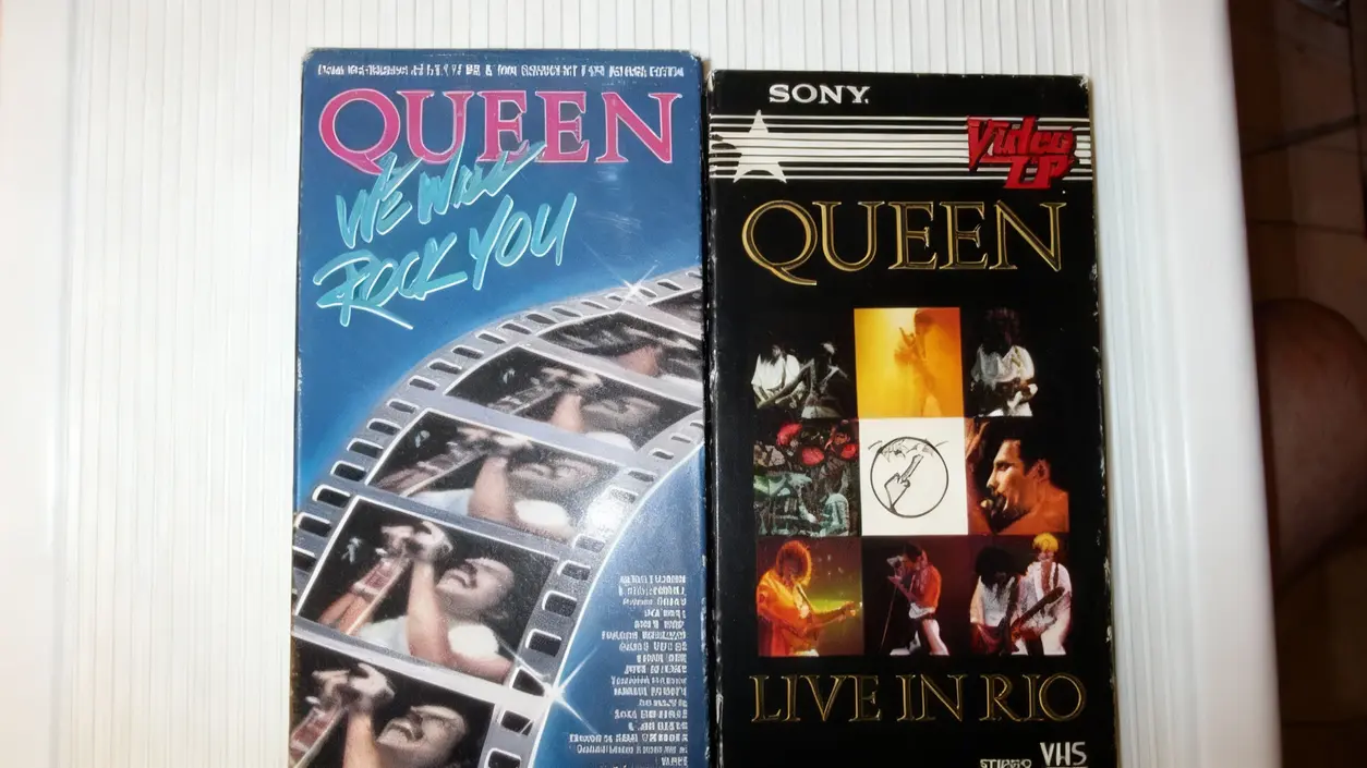 Due videocassette VHS dei Queen poggiate su un tavolo bianco