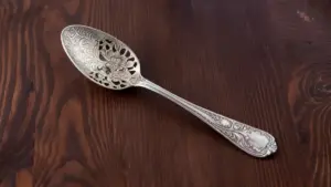 Cucchiaio d'argento antico decorato su superficie di legno scuro